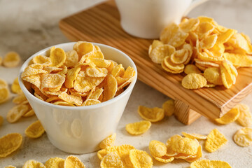 Bowl with tasty cornflakes on light background