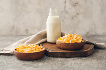 Bowls with tasty cornflakes on grey background