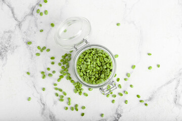 Obraz na płótnie Canvas Jar with green coffee beans on light background