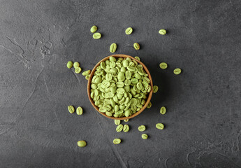 Bowl with green coffee beans on dark background