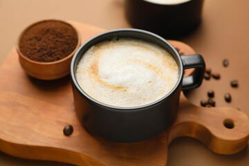 Cup of hot cappuccino on color background