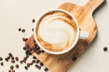 Cup of hot cappuccino on light background