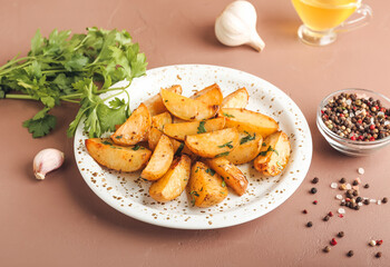 Plate of tasty fried potatoes with parsley on color background