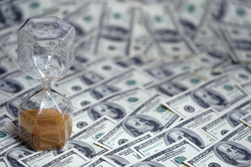 Time is money. Hourglass stand on a layer of notes. Dollars. Watch. Clock. Countdown. American...