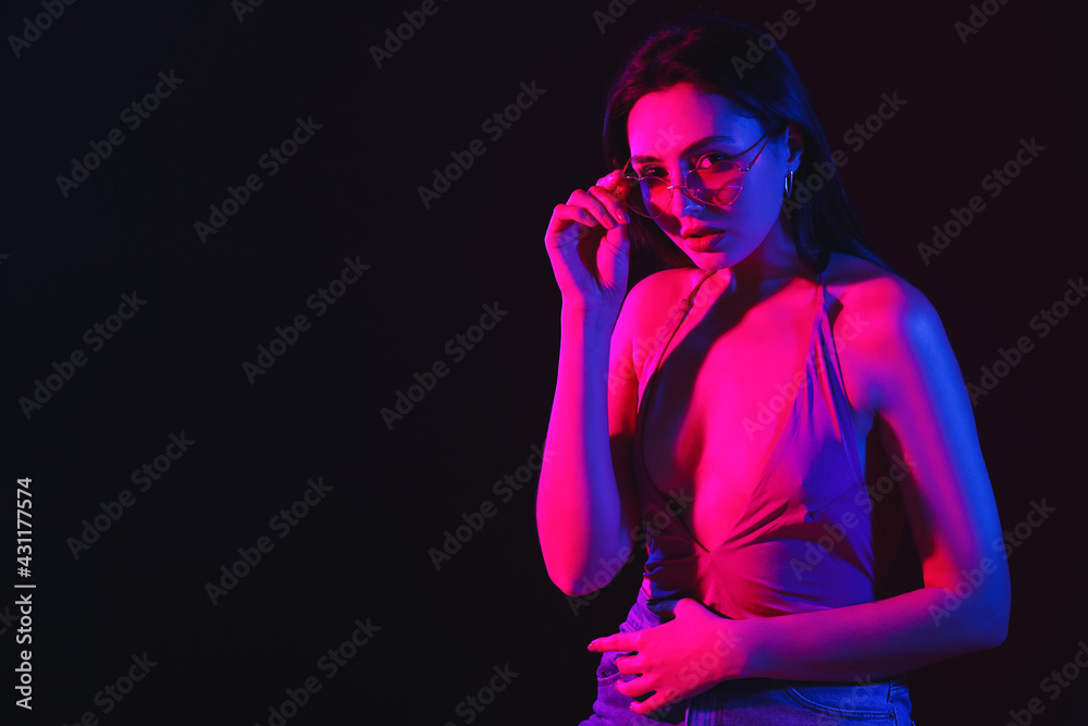 Wall mural toned portrait of beautiful young woman on dark background