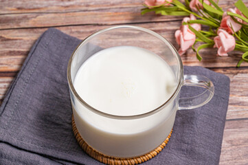 a cup of milk on wood background