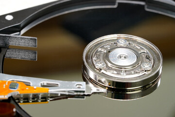 Hard disk spindle and recording head close-up. Computer detail, data recording and information storage. Storage device