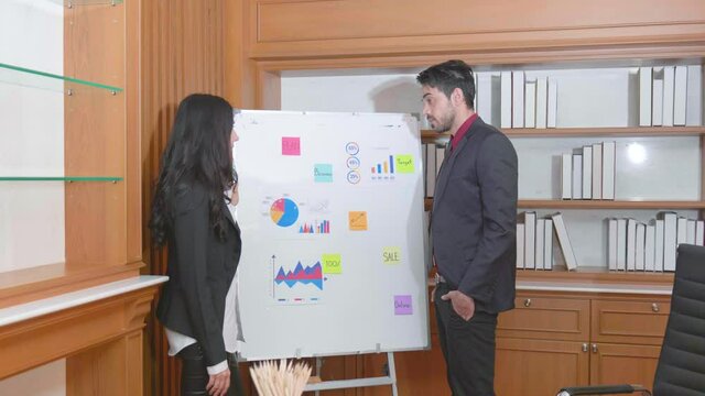 Businesswoman discuss a presentation with her co-worker.