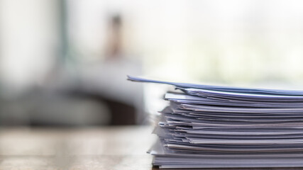 Exam answer sheet pile, blurry application document paperwork stack on office work table in...