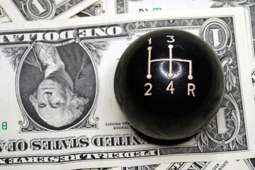The Car speed knob close-up lies a dollar banknote.  Car speed knob close-up                       ...