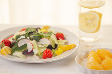 エディブルフラワーや苺を乗せたかわいいサラダのイメージ