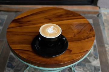A cup of cappuccino on the table is ready to drink while taking a relaxing break.