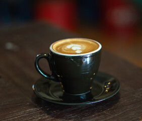 A cup of cappuccino on the table is ready to drink while taking a relaxing break.