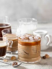 Tasty ice coffee with milk, cream and set with different types of coffee drinkson gray background with copy space. Ice coffee with milk, espresso, cappuccino and mocha coffee.