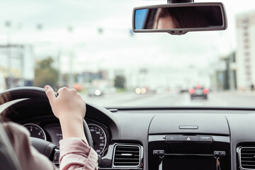 woman is driving on the highway. View from the back seat of the car
