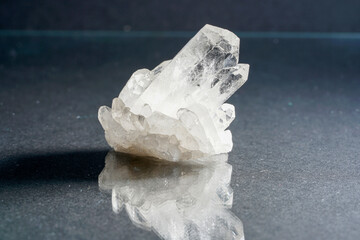 Closeup shot of a shiny quartz crystal reflecting on the gray table