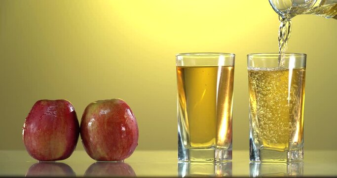 close-up of pouring juice into a glass. there are fresh red apples on the table nearby. 4k video