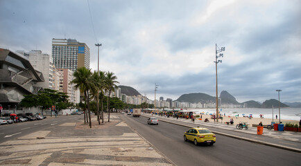 Obraz premium On Avenida Atlantica people go in for outdoor activities. Moving vehicles