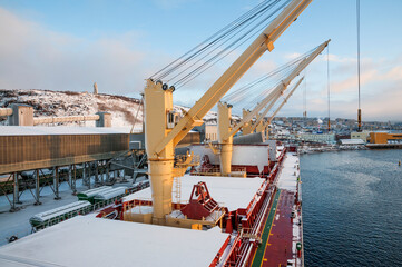 Dry cargo deck covered with a thin layer of snow
Bulk carrier at the mooring wall in the seaport, awaiting loading operations