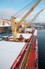 Dry cargo deck covered with a thin layer of snow
Bulk carrier at the mooring wall in the seaport, awaiting loading operations