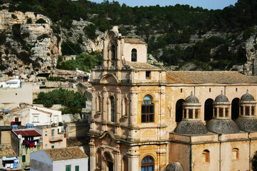 Cattedrale di un paese del sud della Sicilia nel ragusano con vista dei monti e abitazioni caratteristiche con i panni stesi