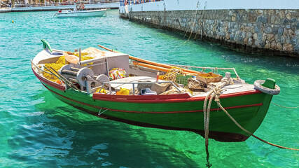 boat in the bay with green water, loaded with fishing gear in the sea