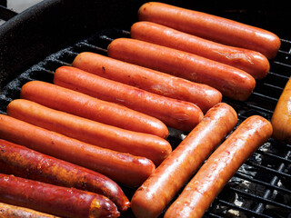 Top view of many  hotdogs on a grill