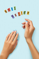 Manicured womans hands with inscription nail design