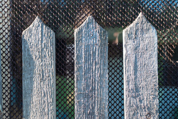 Wooden fence with triangular top and metal mesh