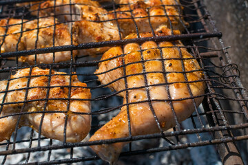 Fried chicken in a metal grill on fire
