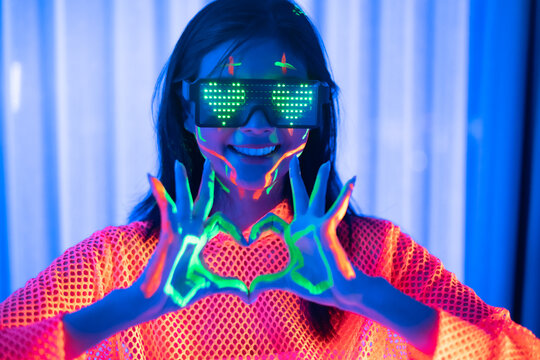Neon  asian woman dancing. Fashion model woman in neon light, portrait of beautiful model with fluorescent make-up, Art and future design of female disco dancer posing in UV, colorful make up.