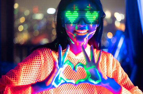 Neon  asian woman dancing. Fashion model woman in neon light, portrait of beautiful model with fluorescent make-up, Art and future design of female disco dancer posing in UV, colorful make up.