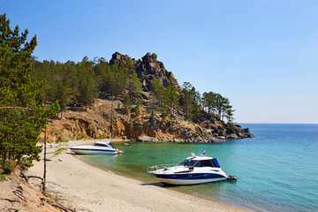The beautiful sandy beach on summer sunny day. Yachts near the shore. Lake Baikal, the Sandy Bay. 