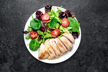 Chicken fillet with salad and spinach. Healthy food on stone background