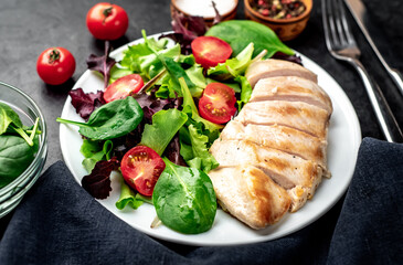 Chicken fillet with salad and spinach. Healthy food on stone background