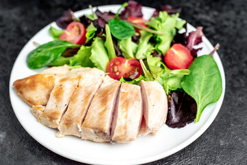Chicken fillet with salad and spinach. Healthy food on stone background