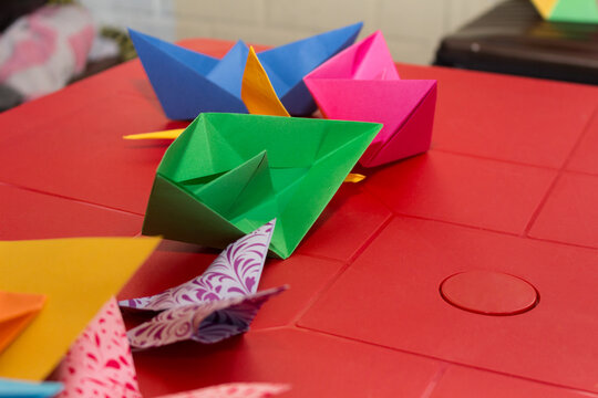 paper boats and butterflies in origami on a red table