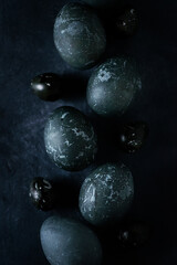 eggs painted dark blue on a black background