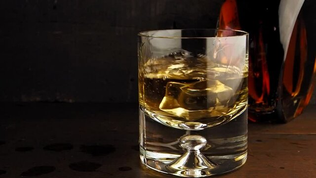 Ice cube splash in whisky glass, slow motion
