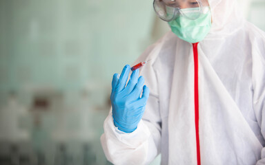 Fototapeta premium The doctor is testing a sample of biological tubes contaminated by Corona-virus Covid 19 and searching for a vaccine or Syrup against the virus. In the laboratory and film samples of infected lung