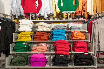 A store shelf full of clothes of various colors