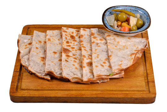 Turkish and arabic traditional food bread sliced (etli ekmek). Kastamonu traditional dish with meat pancake anatolian lahmacun. in a wooden plate, on a white background and shadow