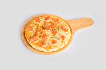 Handmade pizza with crab sticks served on a wooden tray isolated with white background