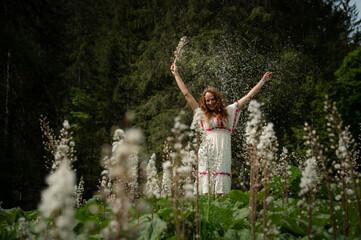 woman in a flower field plays with the petals