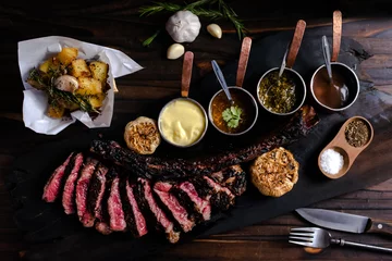 Foto op Canvas tomahawk steak on a wooden cutting board placed on a wooden table © Shutter-G