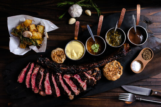 tomahawk steak on a wooden cutting board placed on a wooden table