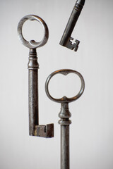 Three old vintage metal keys on white background. Security concept. Antique objects close up. Castle key secret