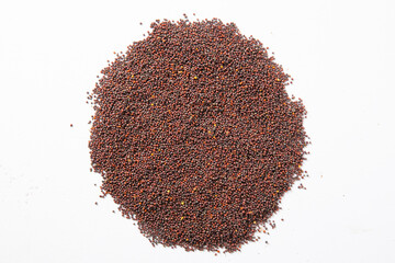 mustard seeds in the wooden scoop, isolated on white.Rai or brown mustard seeds