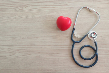 Top view of red heart love and stethoscope on wooden background with copy space.