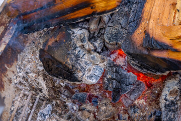 Close up of a red fire flame on a burning firewood tree. Warm winter evening near fireplace, cooking on fire